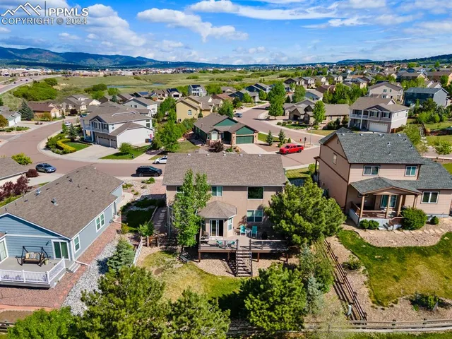 an aerial view of a house with a garden and lake view