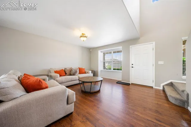 a living room with furniture and wooden floor