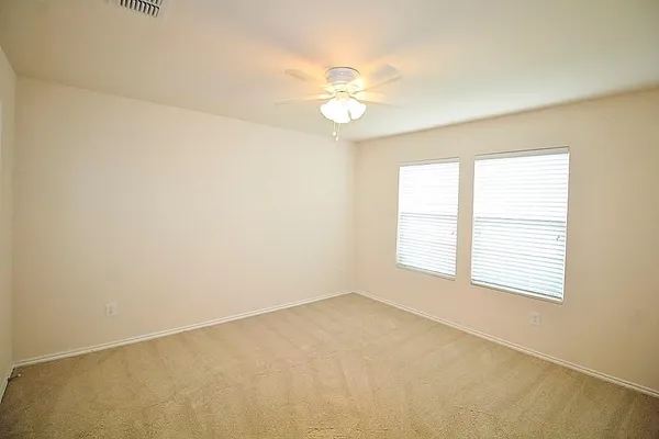 an empty room with a window and a fan
