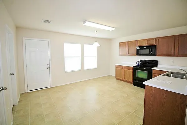 a kitchen with stainless steel appliances granite countertop a stove a sink and a refrigerator