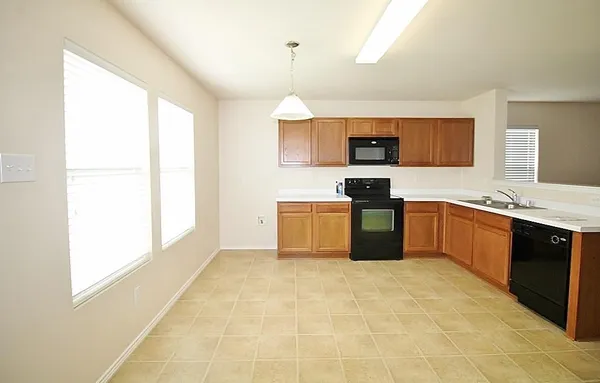 a kitchen with a window a sink and a microwave