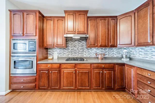 a kitchen with stainless steel appliances granite countertop a refrigerator and cabinets