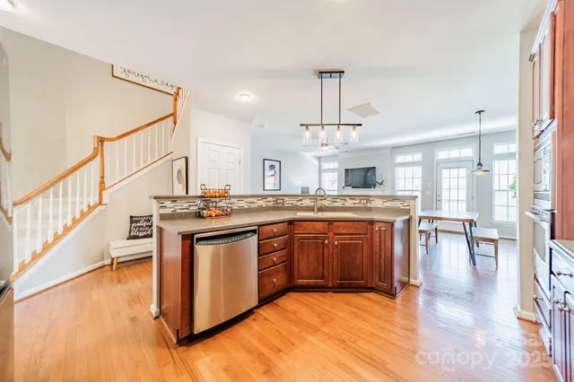 a kitchen with stainless steel appliances granite countertop a stove and a wooden floors