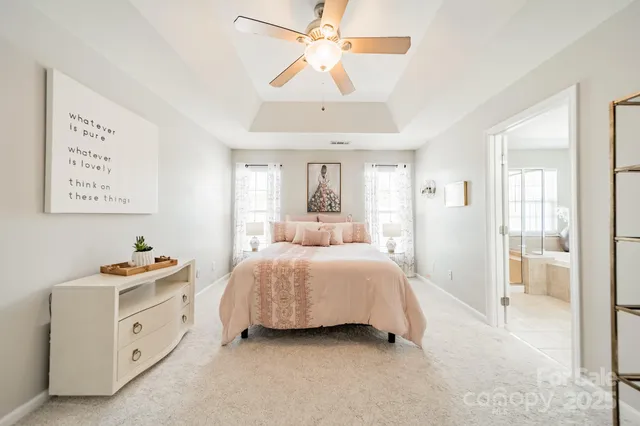 a spacious bedroom with a bed and a chandelier