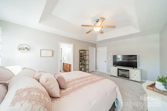 a bedroom with a large bed a flat tv screen and a dresser