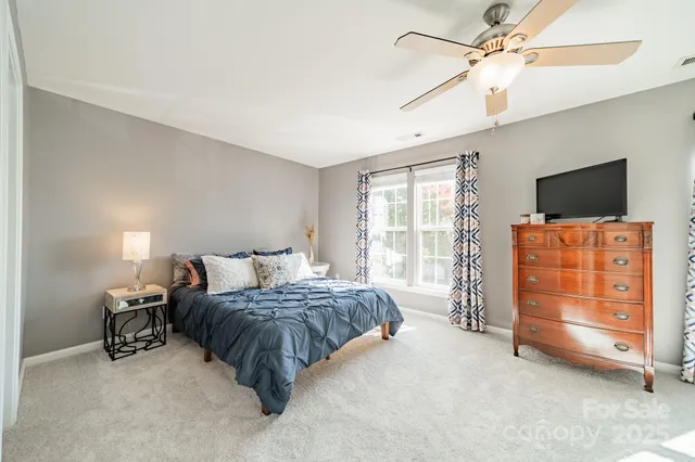 a bedroom with a bed and a flat tv screen on dresser
