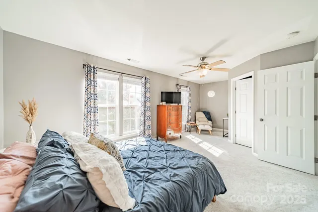 a bed sitting in a bedroom next to a window