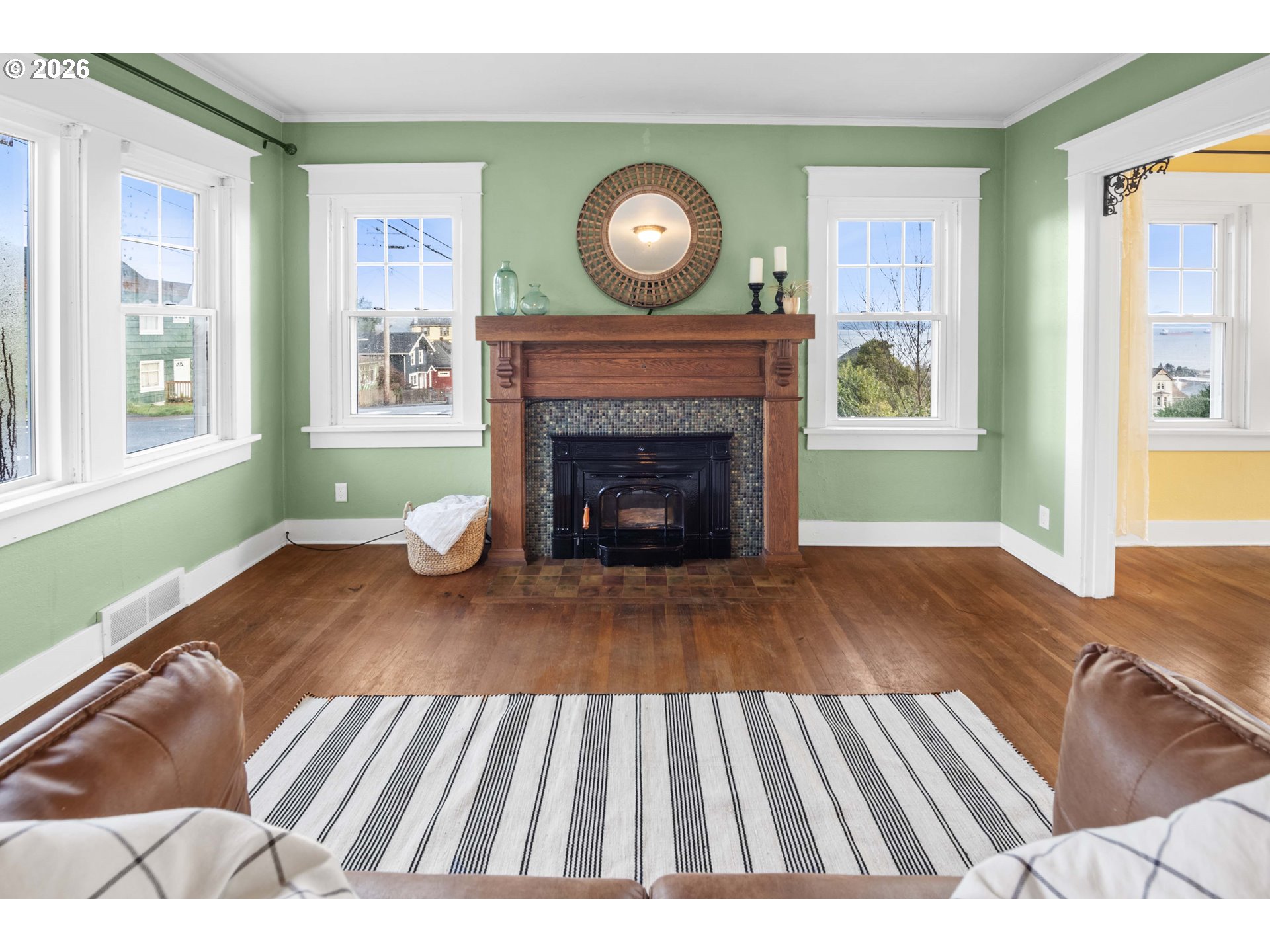 1014 8th Street Astoria, OR 97103 - Photo 2 of 25 a view of an empty room with wooden floor fireplace and a window