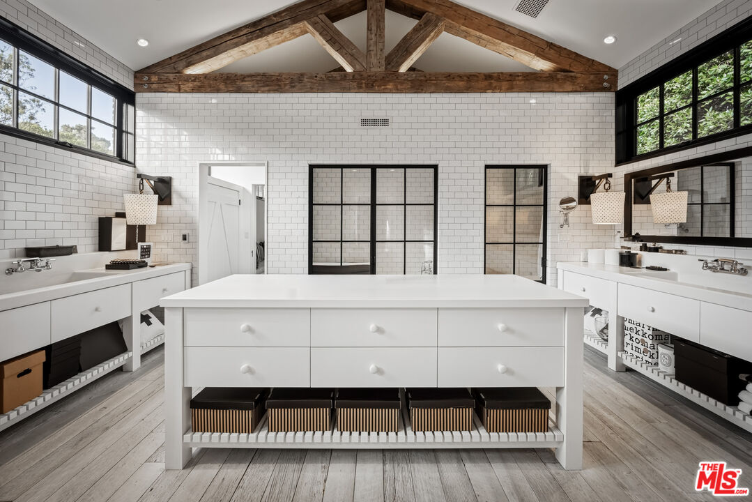 13215 Riviera Ranch Road Los Angeles, CA 90049 - Photo 21 of 37 a spacious bedroom with a bed and a fireplace