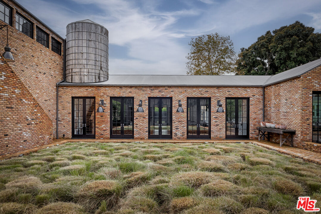 13215 Riviera Ranch Road Los Angeles, CA 90049 - Photo 29 of 37 a view of a brick house with many windows