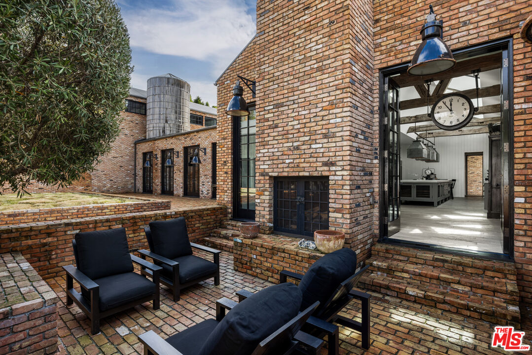 13215 Riviera Ranch Road Los Angeles, CA 90049 - Photo 31 of 37 a view of a patio with couches table and chairs with wooden floor and fence