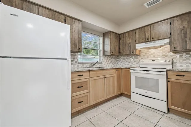 a kitchen with cabinets appliances and a window