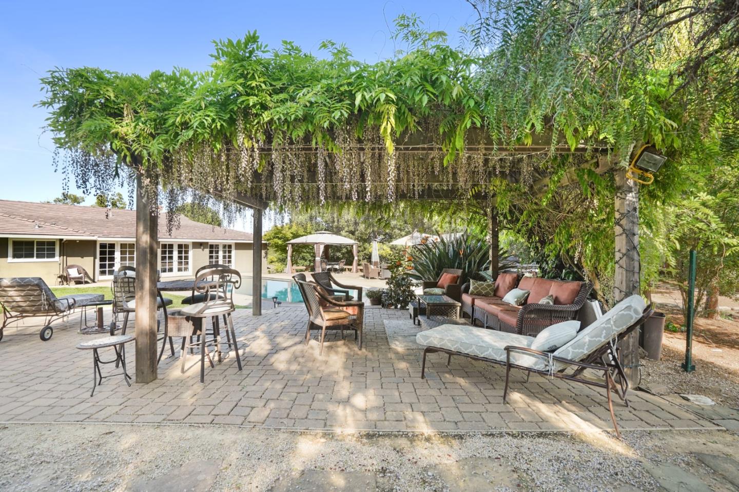 14160 Miranda Road Los Altos Hills, CA 94022 - Photo 20 of 30 a view of a patio with table and chairs potted plants and large tree