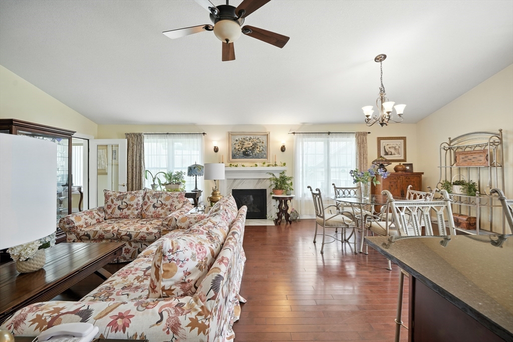 46 Palmer Road, Unit 28 Monson, MA 01057 - Photo 13 of 38 a living room with furniture dining table a fireplace and a chandelier