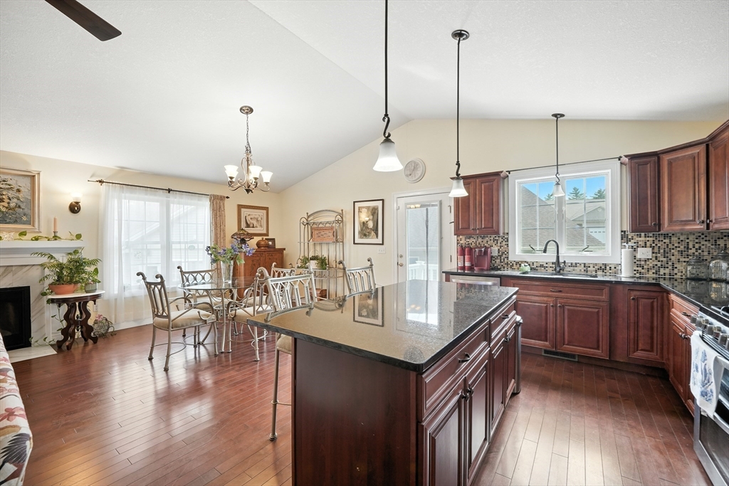 46 Palmer Road, Unit 28 Monson, MA 01057 - Photo 5 of 38 a kitchen with granite countertop a stove a sink a center island a dining table and chairs