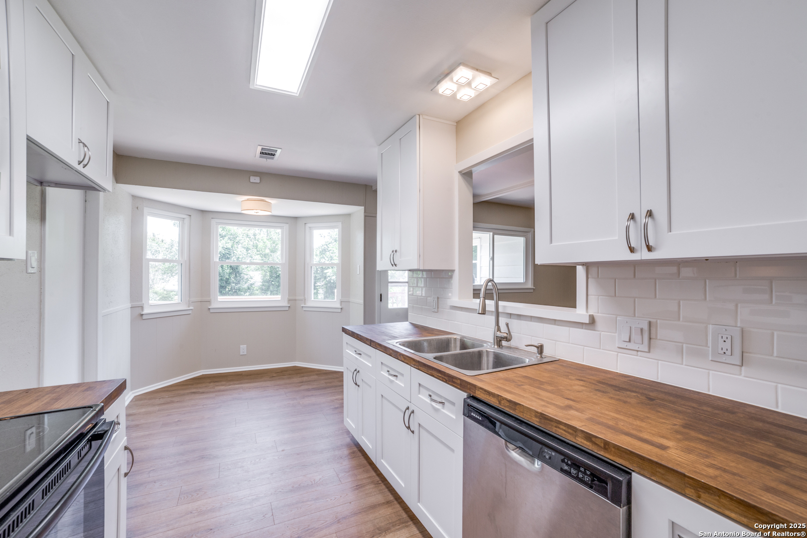 3323 Old Forge San Antonio, TX 78230 - Photo 12 of 26 a kitchen with granite countertop white cabinets and wooden floor