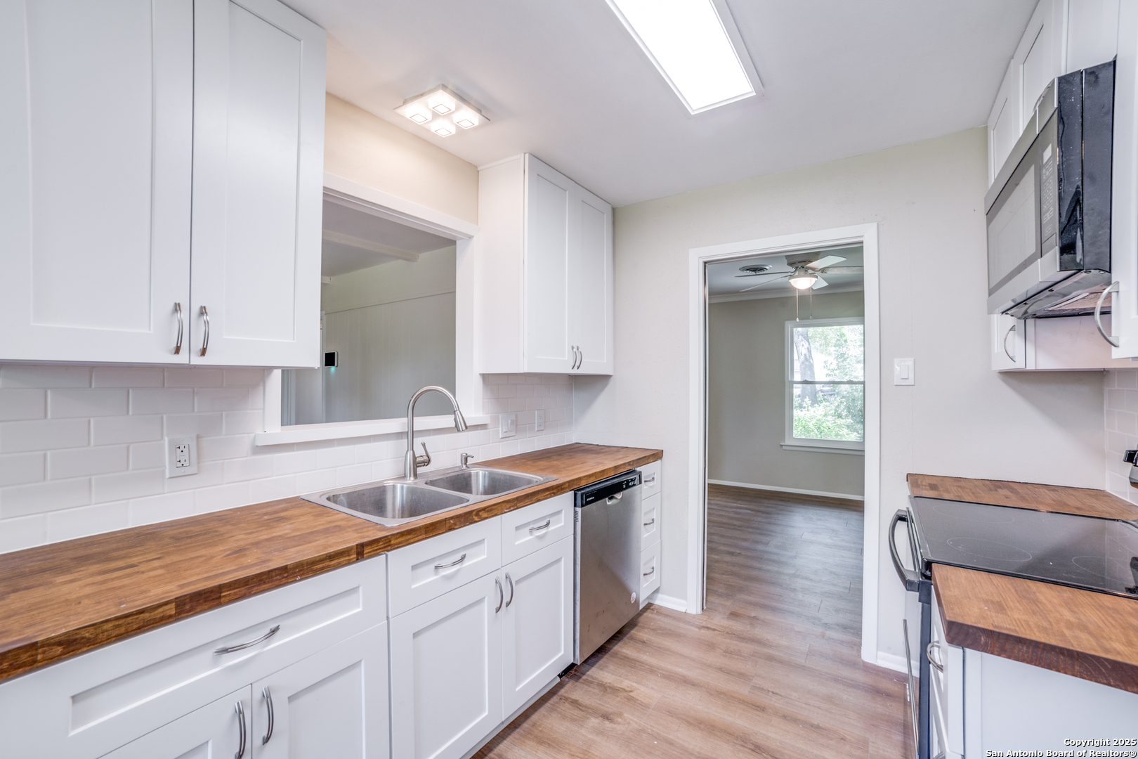 3323 Old Forge San Antonio, TX 78230 - Photo 15 of 26 a kitchen with granite countertop white cabinets and white appliances