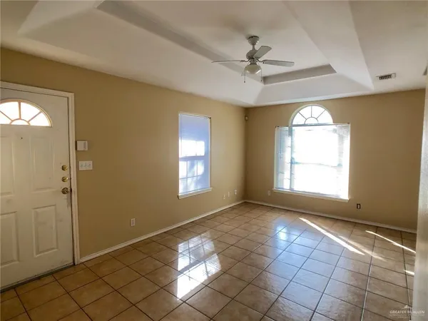 a view of an empty room and window chandelier fan