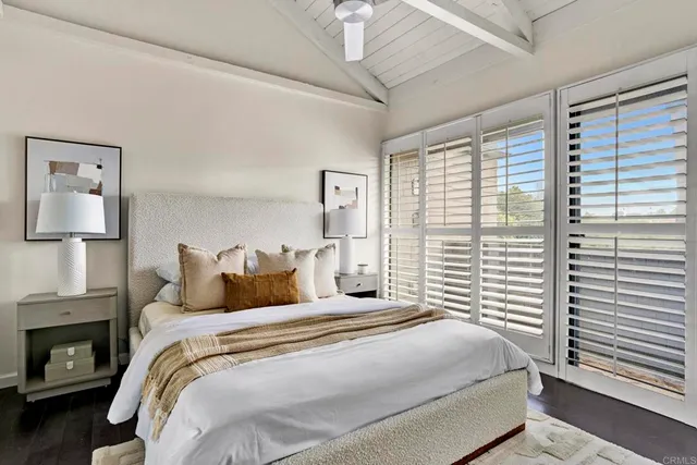 a bedroom with a large bed and a lamp on dresser