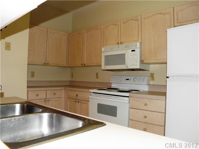606 Stone Village Drive, Unit 606 Fort Mill, SC 29708 - Photo 4 of 11 a kitchen with granite countertop a sink a stove and cabinets
