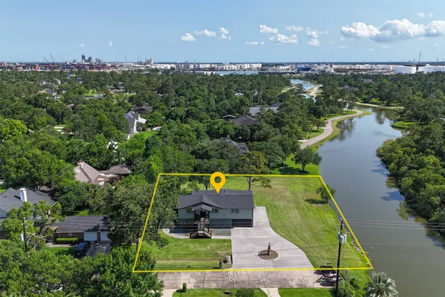 an aerial view of a house with a garden and lake view