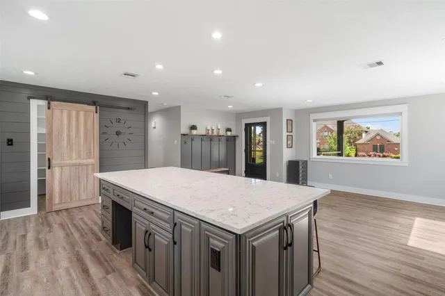 a kitchen with a wooden floor and large window