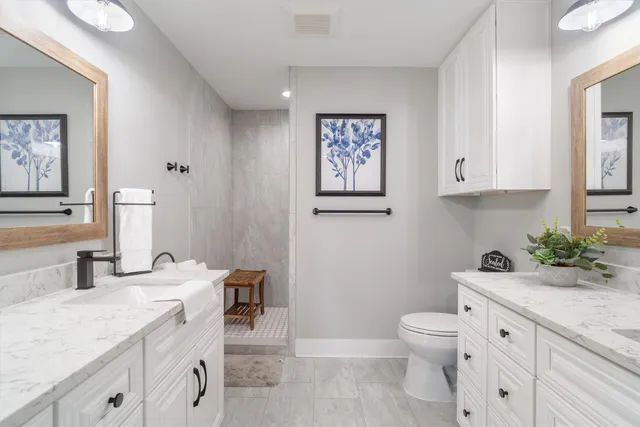 a bathroom with a granite countertop toilet sink and mirror