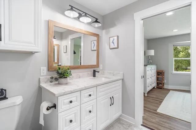 a spacious bathroom with a granite countertop sink mirror and a toilet