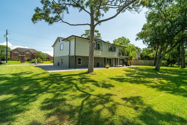a view of a house with backyard and deck
