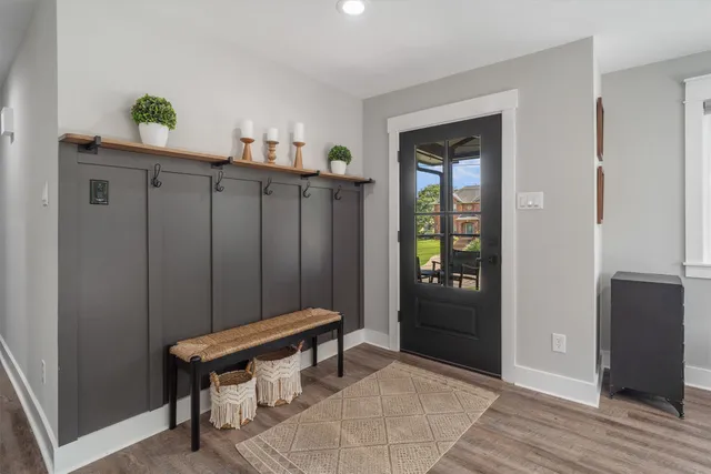 a view of a hallway with wooden floor and a bedroom