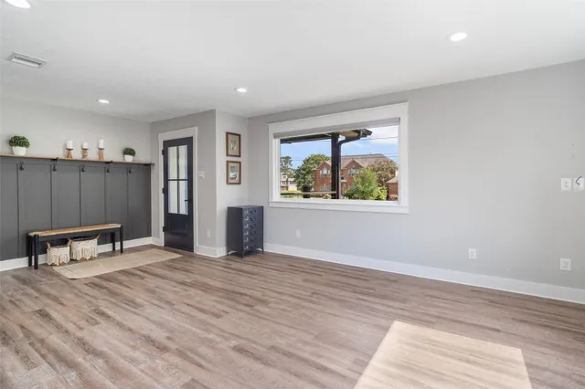 a view of an empty room with window and a kitchen