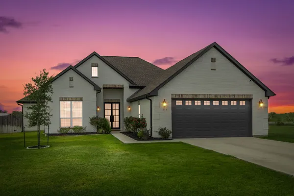 a front view of a house with a garden and yard