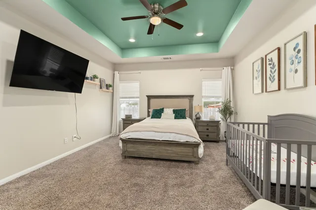 a spacious bedroom with a bed and a flat screen tv