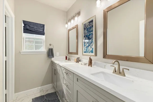 a white bath tub sitting next to a white sink and vanity