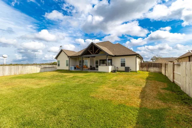 a view of a house with a big yard and large trees