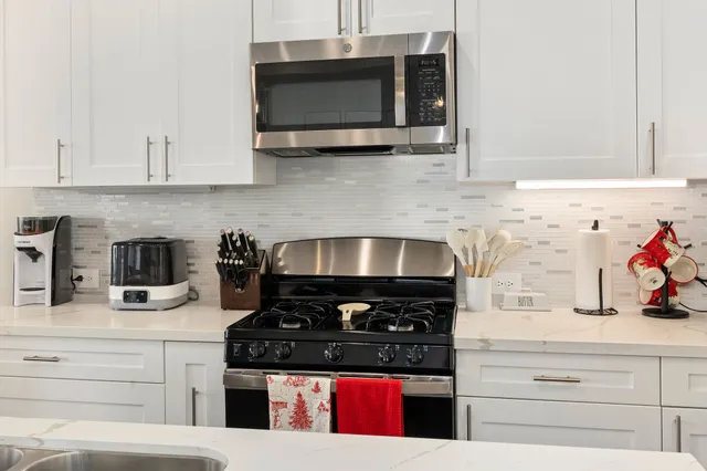 a kitchen with stainless steel appliances granite countertop a stove and a microwave