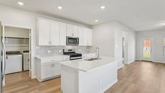 a kitchen with a sink a stove and cabinets