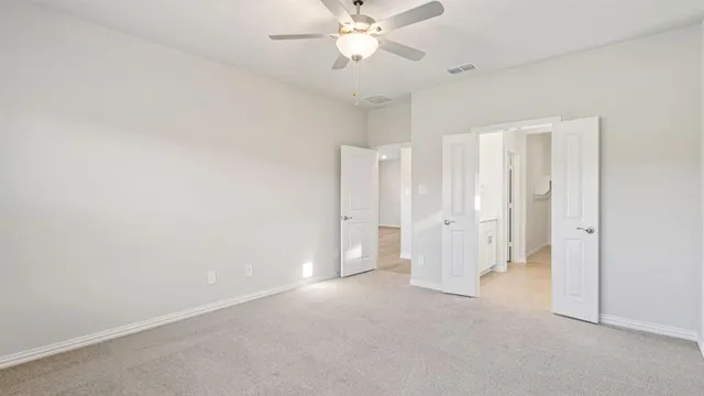 an empty room with a ceiling fan and bathroom