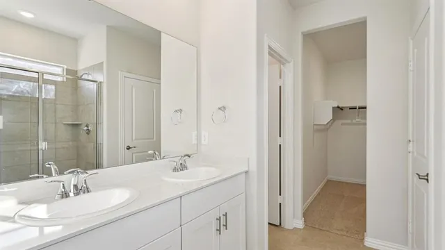 a bathroom with a double vanity sink mirror and shower