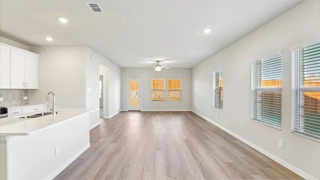 a large kitchen with stainless steel appliances a large window a sink and a refrigerator