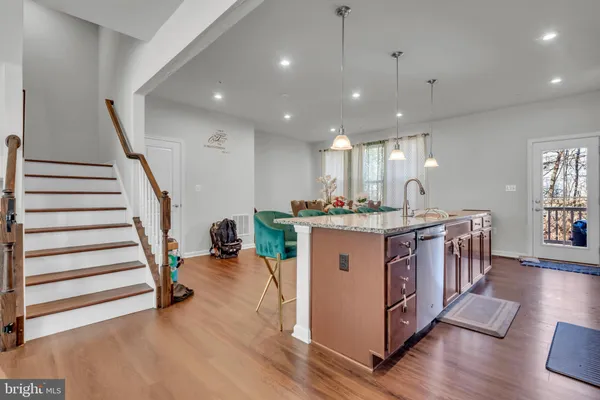 a kitchen with a sink and wooden floor