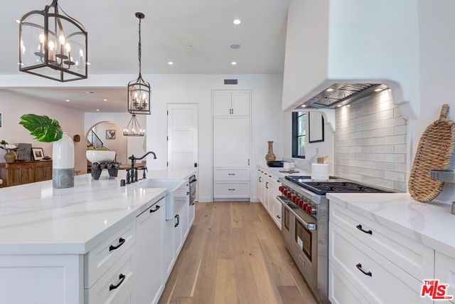 a kitchen with stainless steel appliances a sink stove and cabinets
