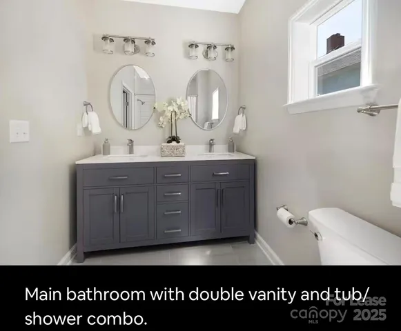 a view of bathroom with sink mirror and window