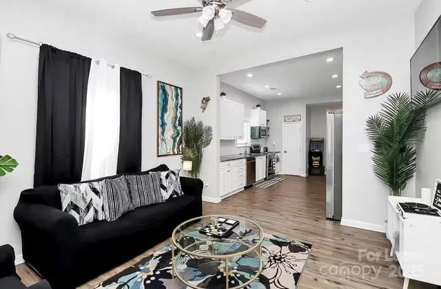 a living room with furniture and view of kitchen