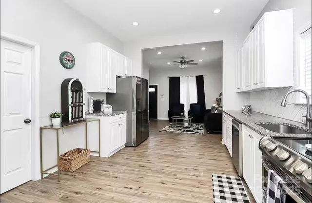 a kitchen with a refrigerator and a stove top oven