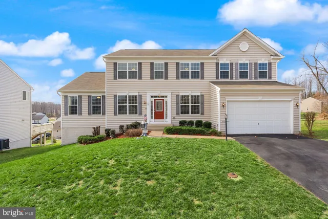 a front view of a house with a garden and yard