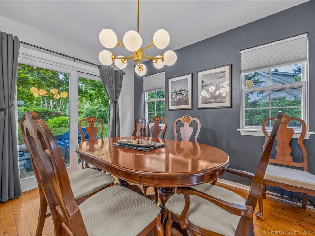 3 Apple Way Madison, CT 06443 - Photo 9 of 31 a view of a dining room with furniture a chandelier and large windows