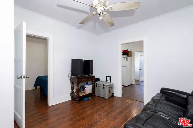 a view of a livingroom with entryway wooden floor and a chandelier fan