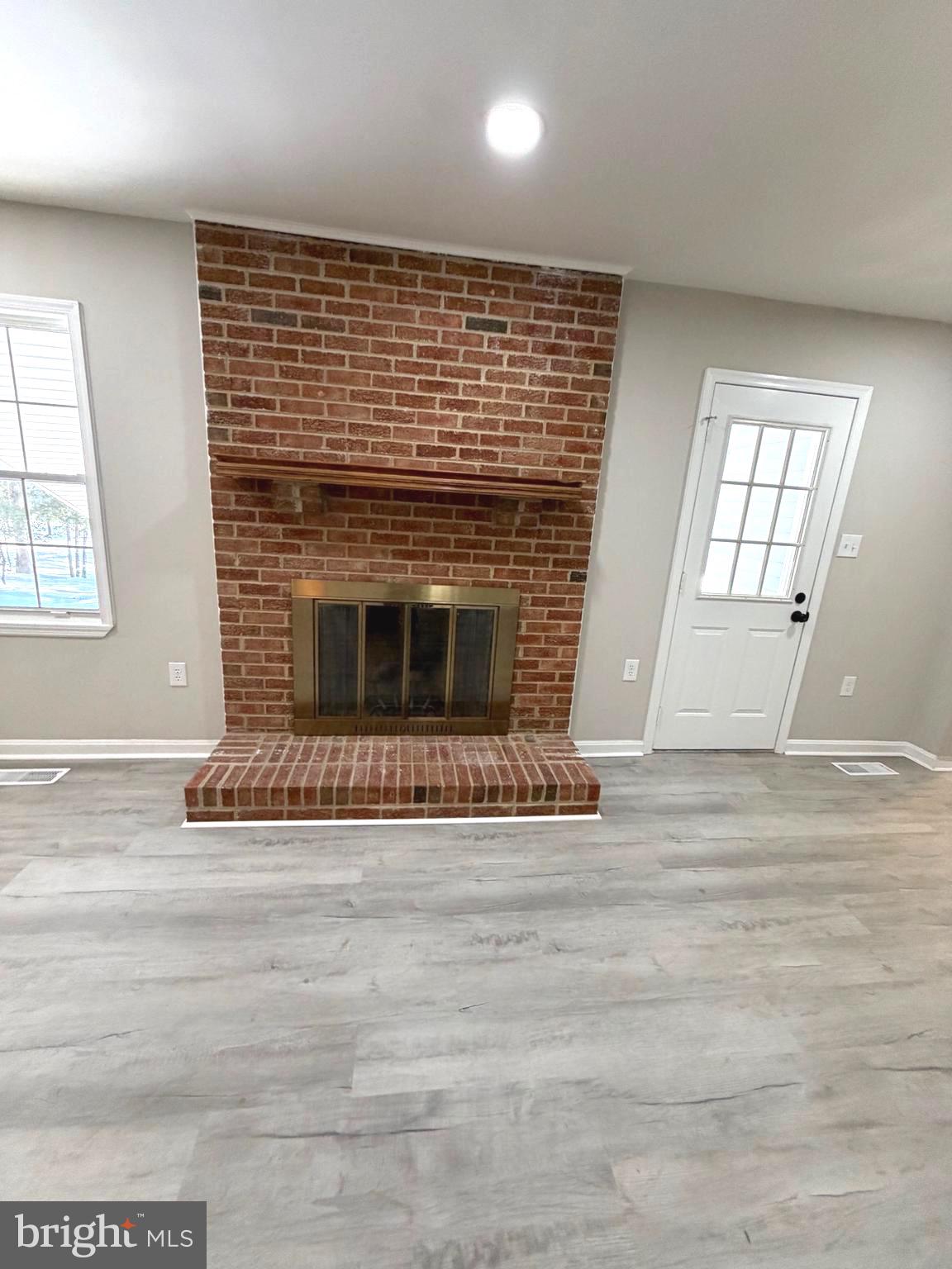 12926 Couples Place Waldorf, MD 20601 - Photo 14 of 29 an empty room with wooden floor and fireplace