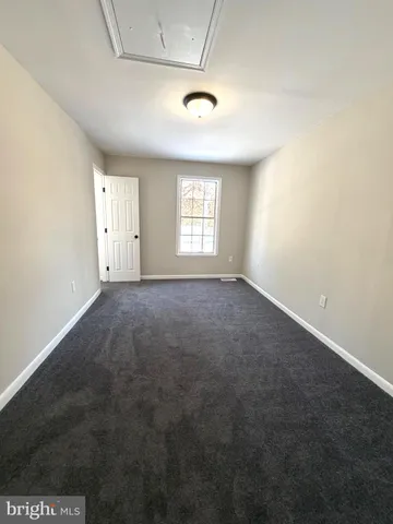 an empty room with a window and a ceiling fan